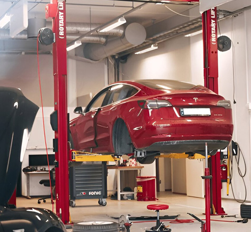 Mekaniker arbetar på bil i modern bilverkstad i Skåne